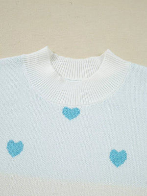 Light blue and white knit sweater with a playful heart pattern and crew neck.