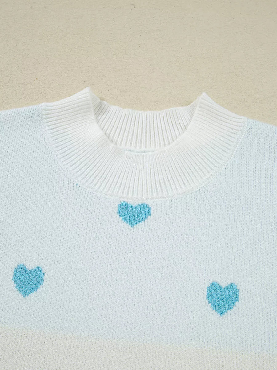 Light blue and white knit sweater with a playful heart pattern and crew neck.