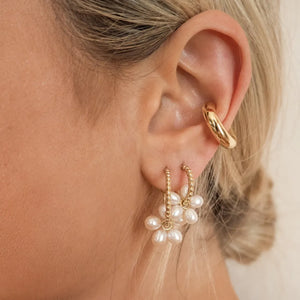 Gold-tone ear cuff and pearl flower hoop earrings with beaded detail.
