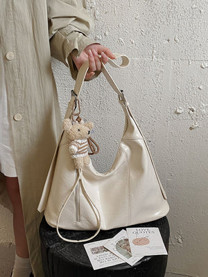 shoulder bag in ivory featuring adjustable strap and relaxed fit