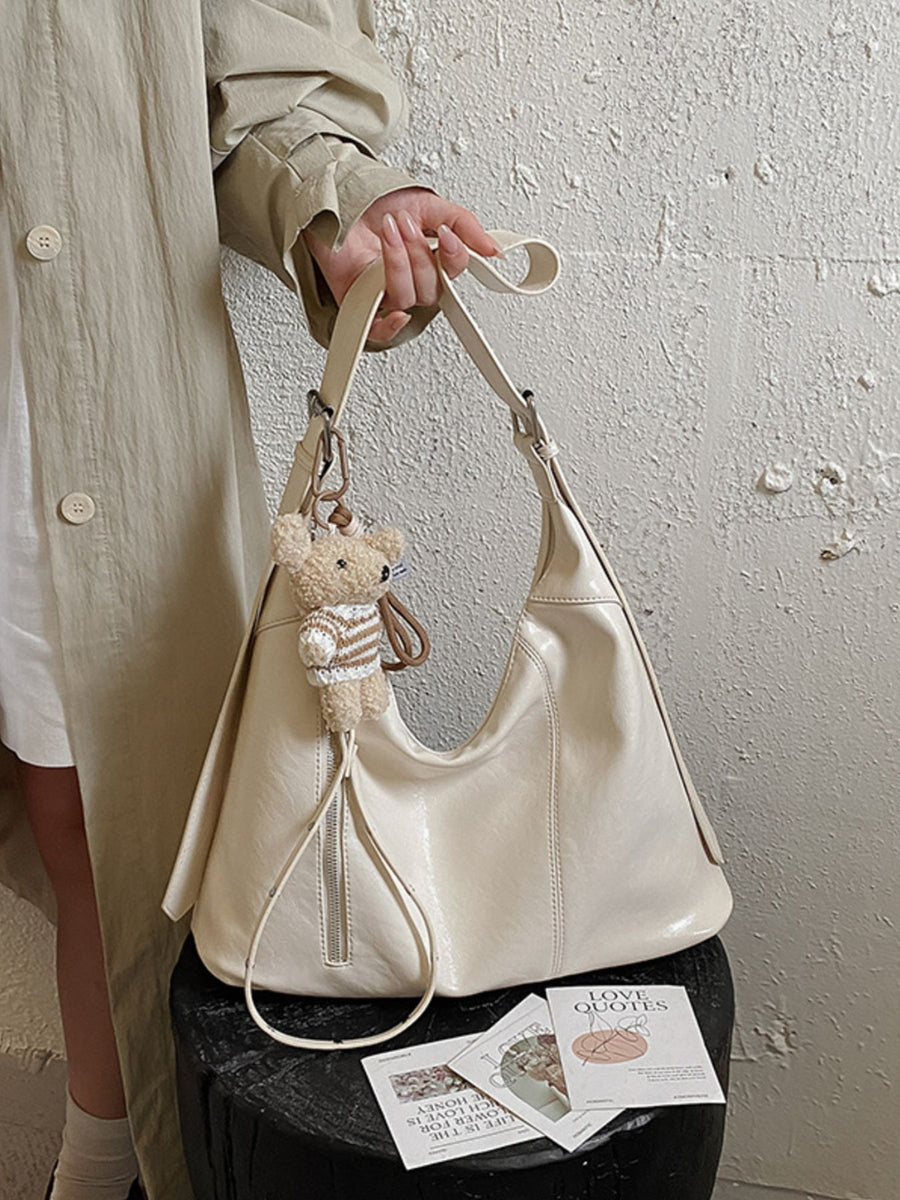 shoulder bag in ivory featuring adjustable strap and relaxed fit