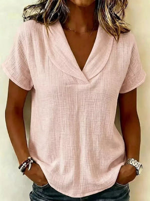Lotus color textured blouse with V-neck and short sleeves, styled casually.