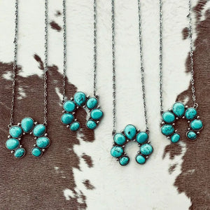 Turquoise horseshoe necklaces with silver chains, featuring multiple stones.