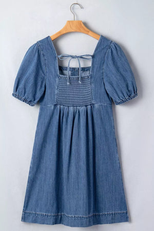 Denim puff sleeve square neck dress with smocked bodice and back tie detail.