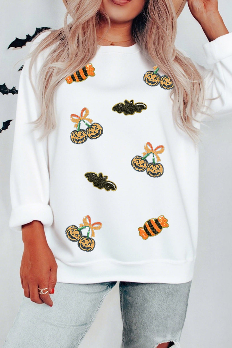 orange pullover sweater featuring sequin embellishment and graphic print