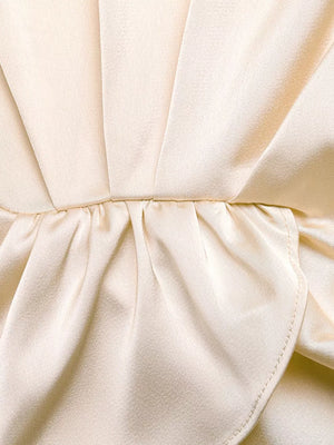 Champagne satin twist-front top detail with ruched waist and flowing pants fabric.