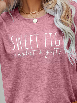 Blush pink graphic t-shirt with white "Sweet Fig Market & Gifts" text.