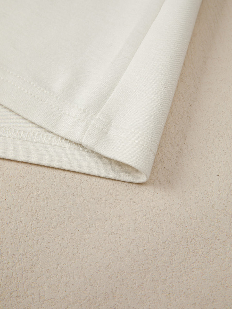 Beige buttoned blouse detail showing hem and stitching