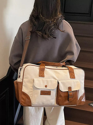 Cream white canvas travel organizer bag with brown leather accents and multiple pockets.