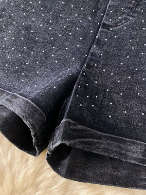 Black denim romper with rhinestone polka dots and cuffed hem.