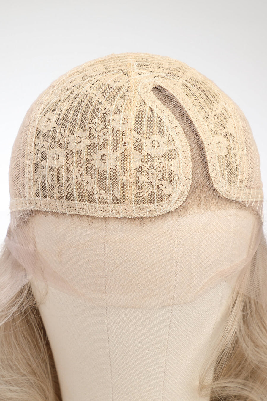 Blonde lace front wig cap with detailed floral lace overlay and mesh construction.