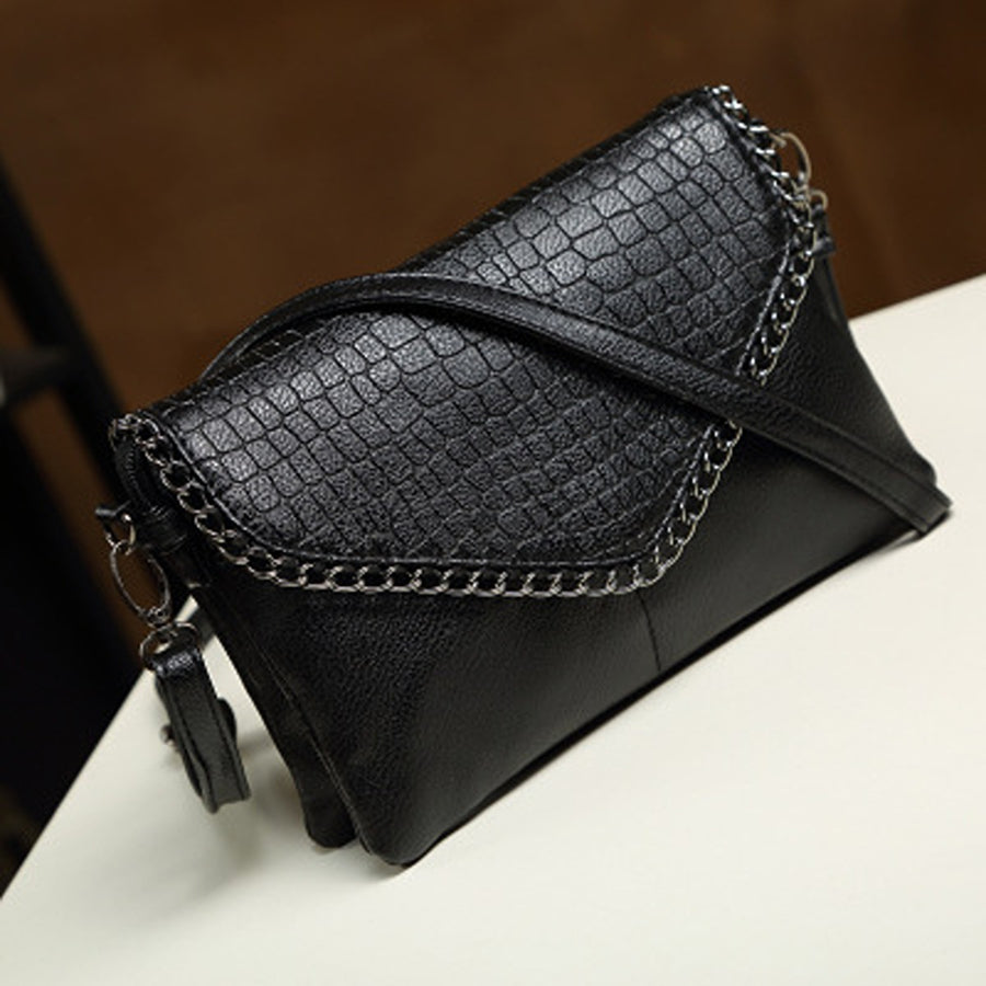 crossbody bag in black with crocodile-print and chain strap detail