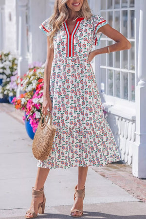 Vibrant floral midi dress with tiered skirt, V-neck, and short sleeves.