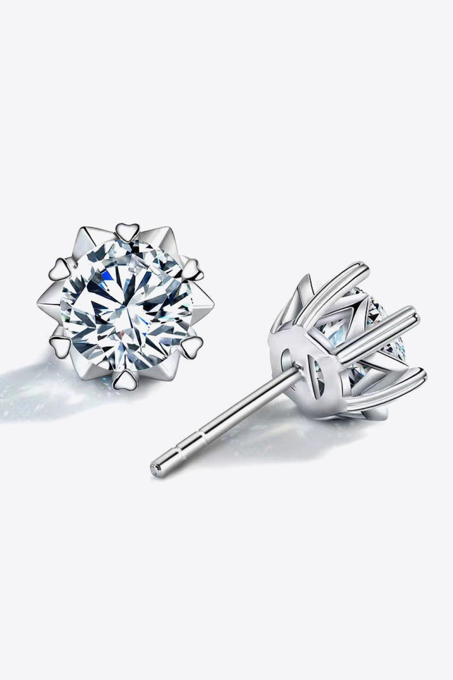 Silver stud earrings with a celestial cut moissanite and heart details.