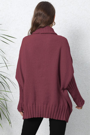 Burgundy ribbed knit turtleneck sweater with batwing sleeves and ribbed cuffs.