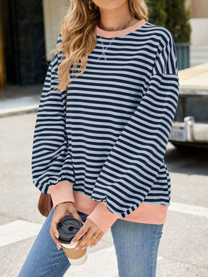 Striped crew neck sweatshirt in navy and light blue with coral cuffs and hem.