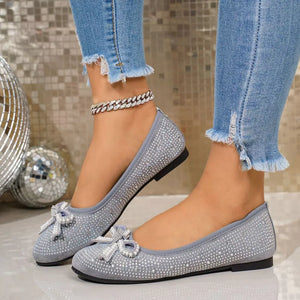 Gray rhinestone-embellished bow flats with a sparkly anklet.
