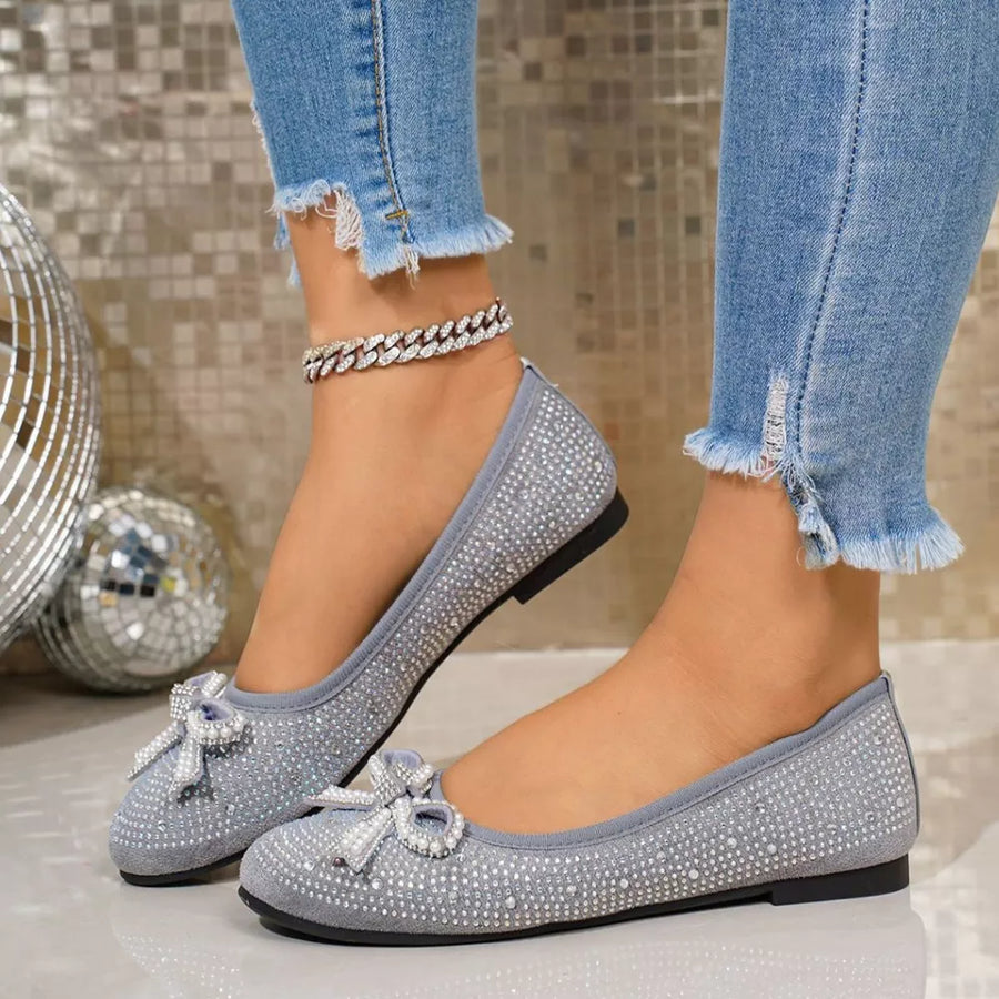 Gray rhinestone-embellished bow flats with a sparkly anklet.