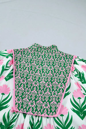 Playful floral blouse with puff sleeves, V-neck, and a green and pink patterned bib detail.