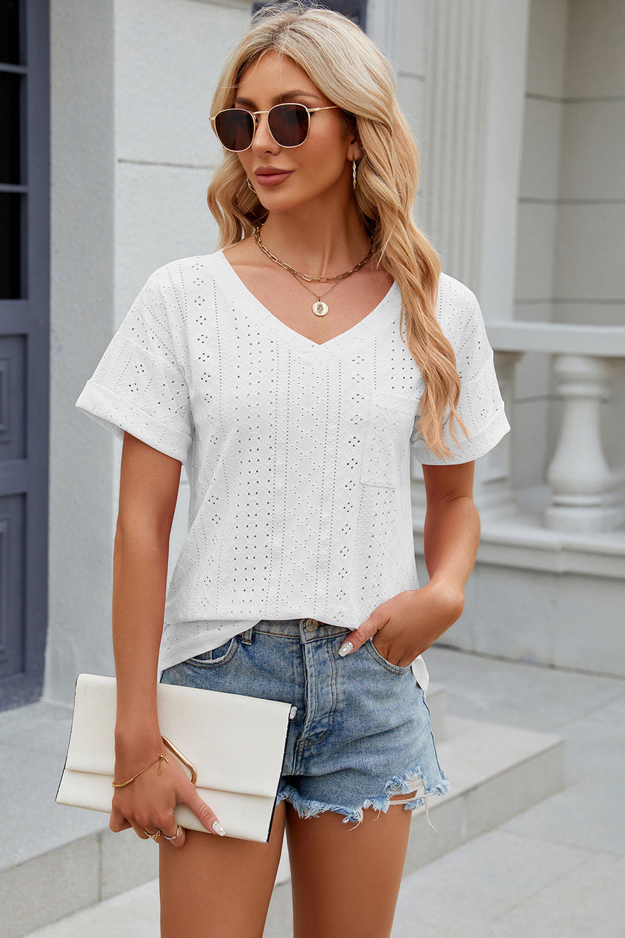 White perforated v-neck t-shirt with rolled sleeves and a chest pocket.
