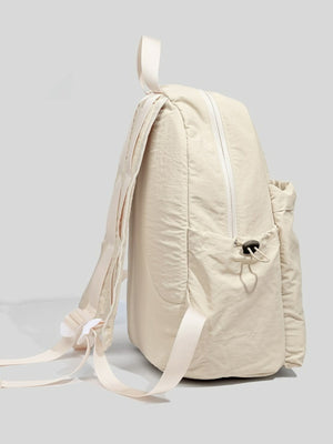 Off-white lightweight nylon backpack with adjustable straps and front drawstring pocket.