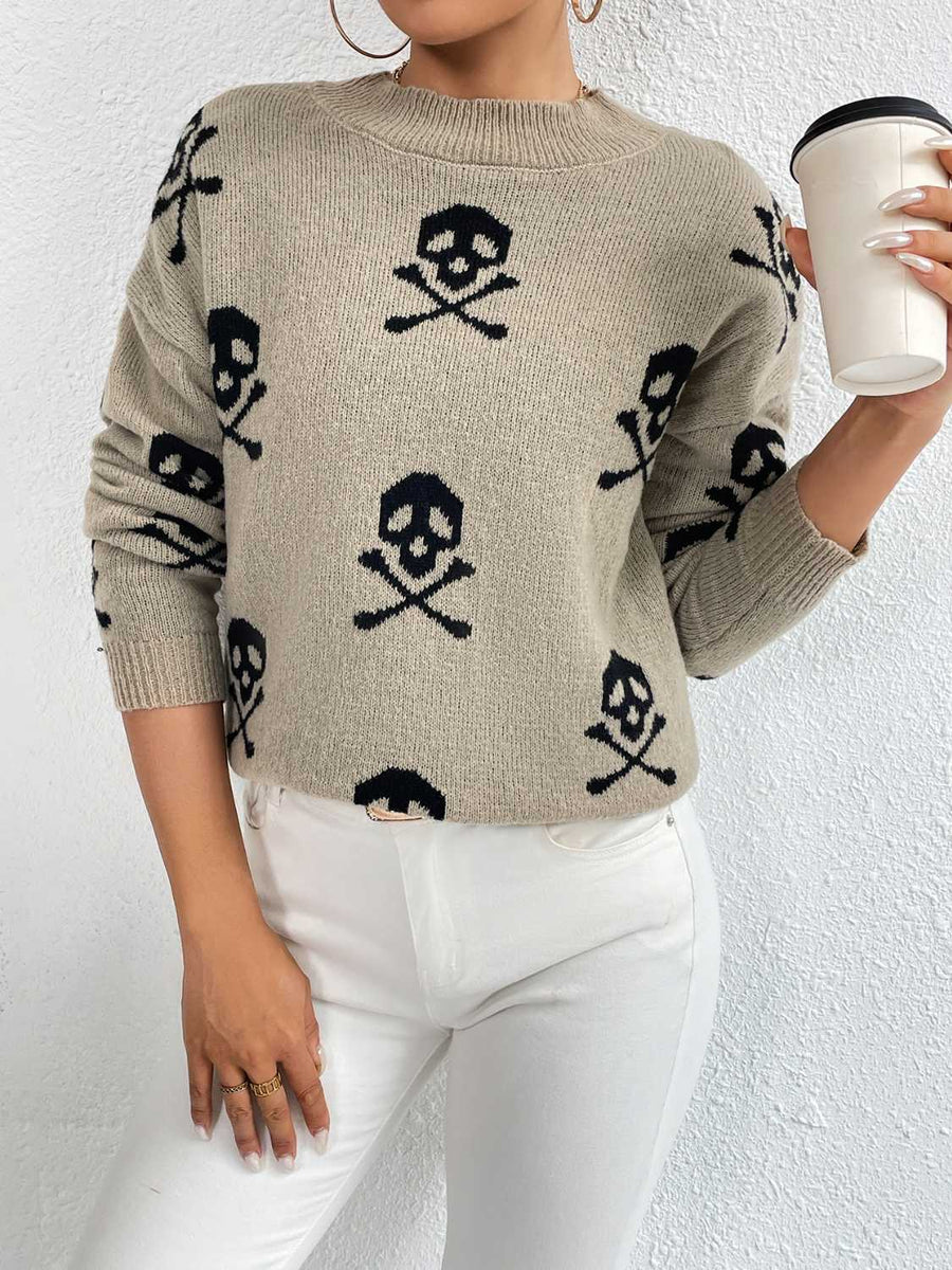 Khaki knit sweater with allover black skull and crossbones print, drop shoulder, and crew neck.