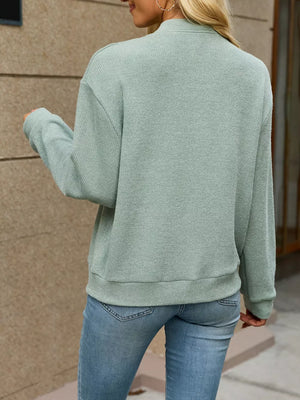 Black zip-up sweater with hip-length and zip-front