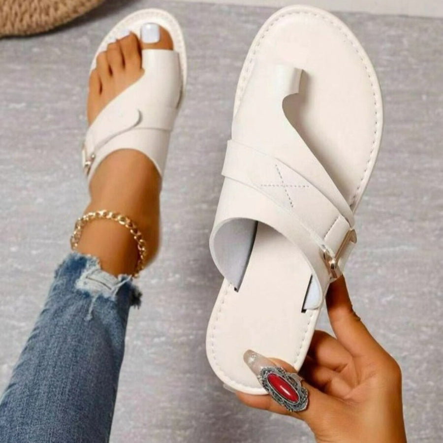 White toe ring sandals with buckle detail and cross strap.