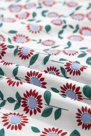 Vibrant floral midi dress in white cotton with red flowers and green leaves.