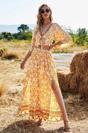 Tangerine floral print crop top with tie front and bell sleeves, paired with a high-waisted maxi skirt with a thigh-high
