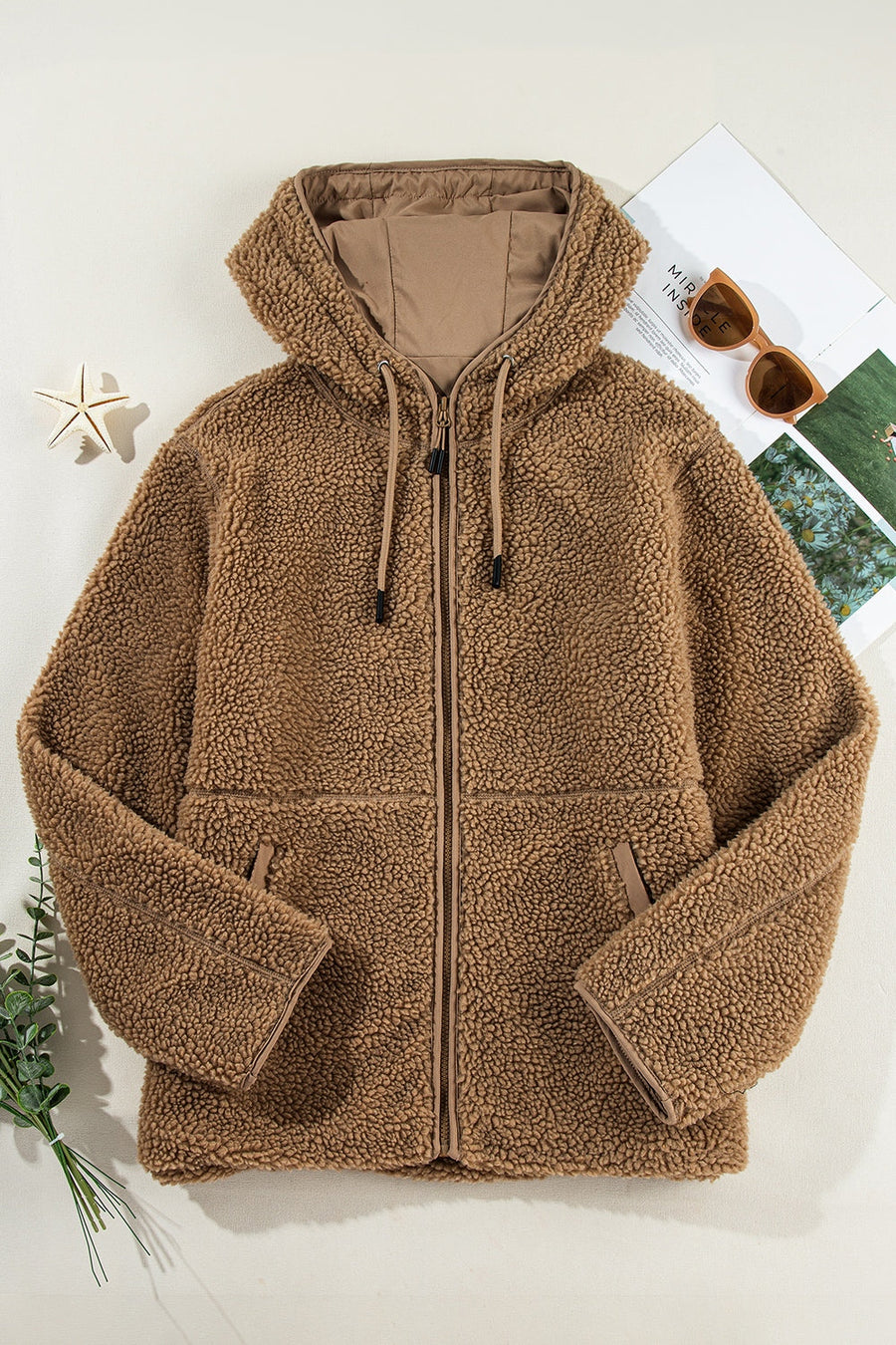 Brown sherpa hooded jacket with contrast lining and zip closure.