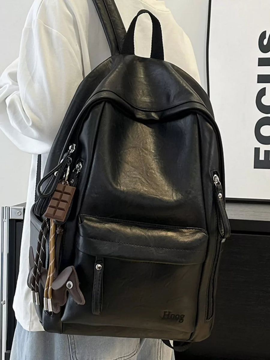 Chic black pu leather medium backpack with front pocket and playful chocolate bar charm.