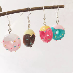Playful donut dangle earrings in pink, brown, hot pink, and pastel blue with sprinkles.