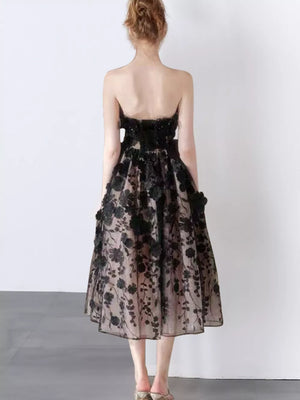 Black midi dress with 3D floral applique and a strapless neckline.