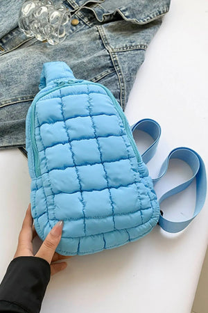 Padded sling bag in Pastel Blue with quilted pattern and top handle.