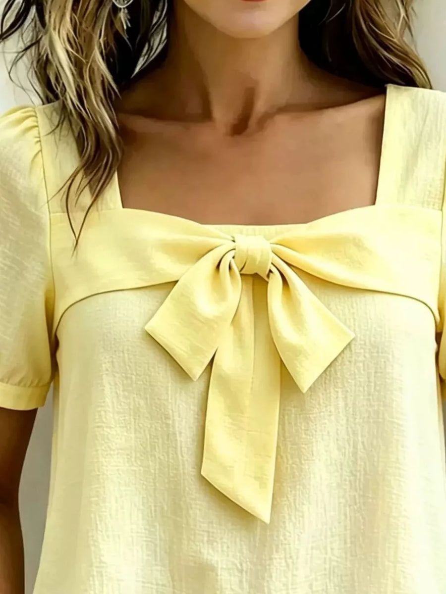 Yellow puff sleeve shirt with a chic bow tie neckline and square collar.