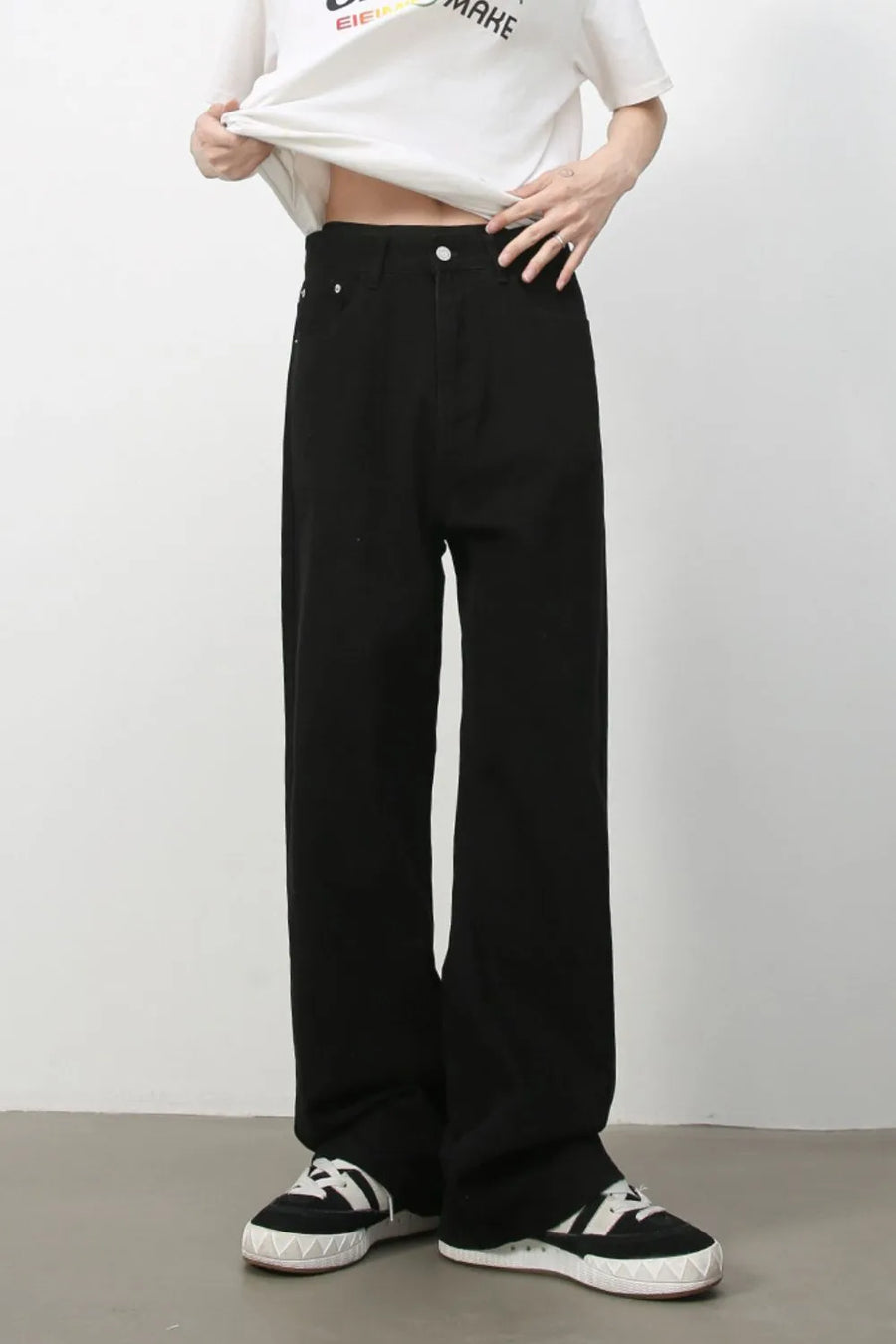Black wide-leg rigid denim trousers with a relaxed fit.