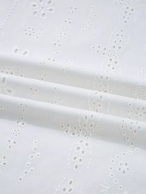 White cotton blouse with delicate eyelet embroidery and ruffled details.