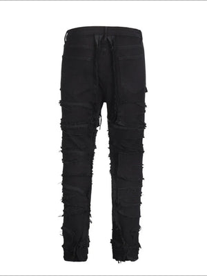 Black denim jeans with layered frayed details and a sculpted fit.