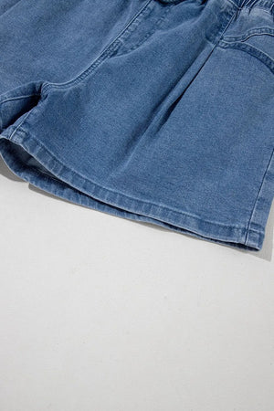 Medium wash denim shorts with paperbag waist and relaxed fit.