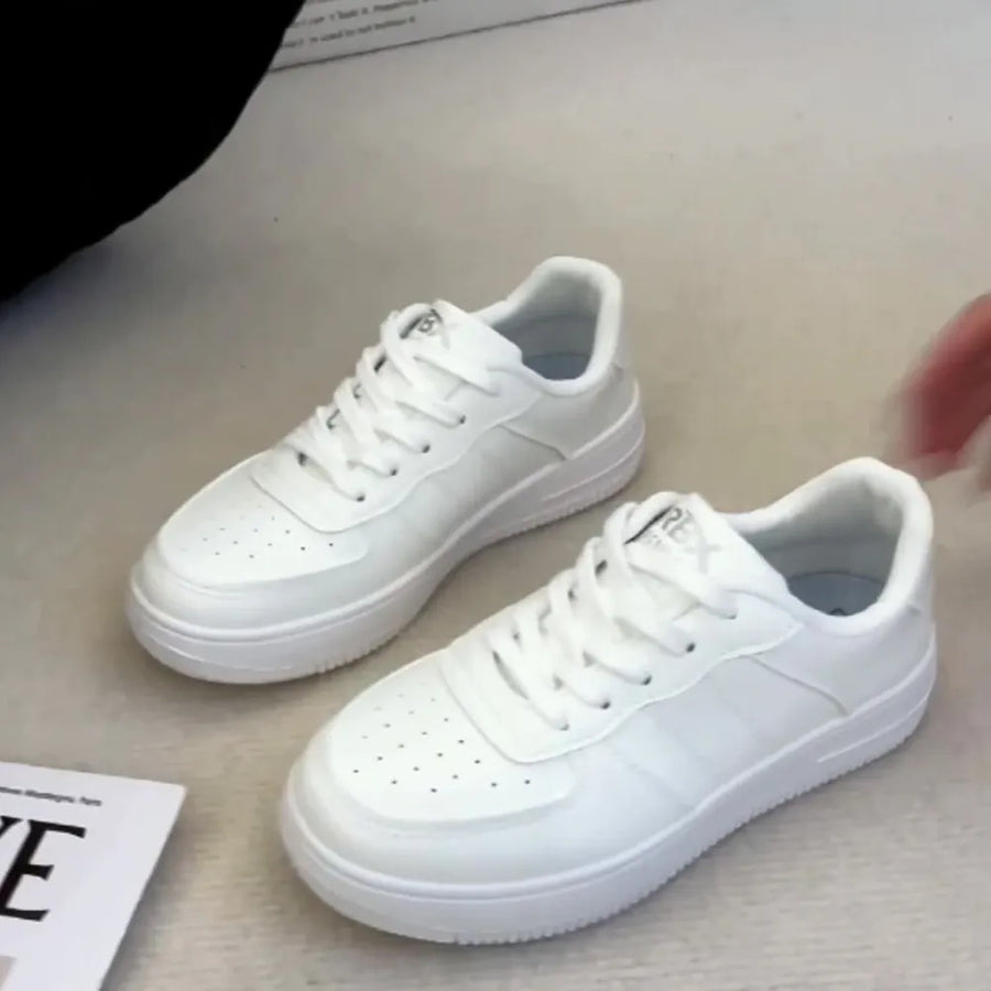 White minimalist platform sneakers with perforated toe boxes and lace-up closure.