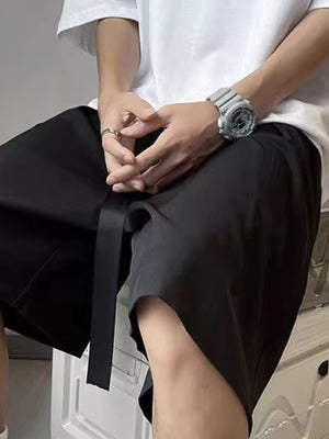 Men's black loose-fit casual shorts with belt detail and pockets
