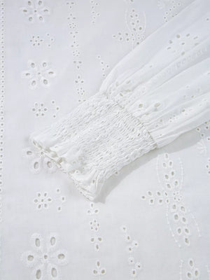 White cotton blouse with eyelet embroidery and smocked cuff detail.