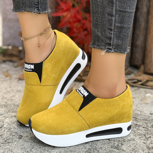Yellow round toe platform slip-on sneakers with black trim and white soles.