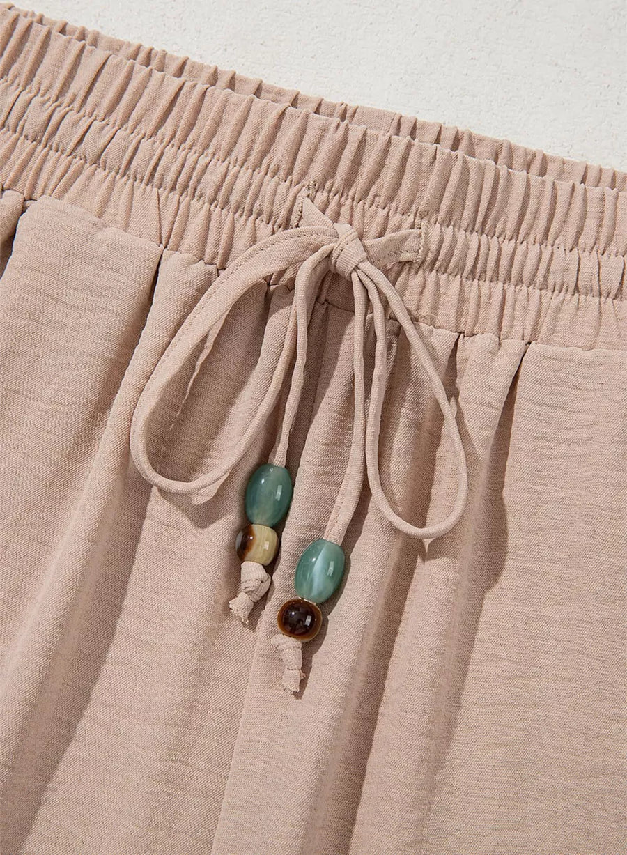 Tan relaxed wide-leg maternity pants with drawstring and beaded detail