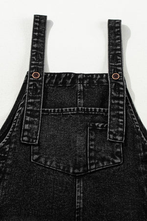 Black denim culotte overalls with distressed details and button straps.