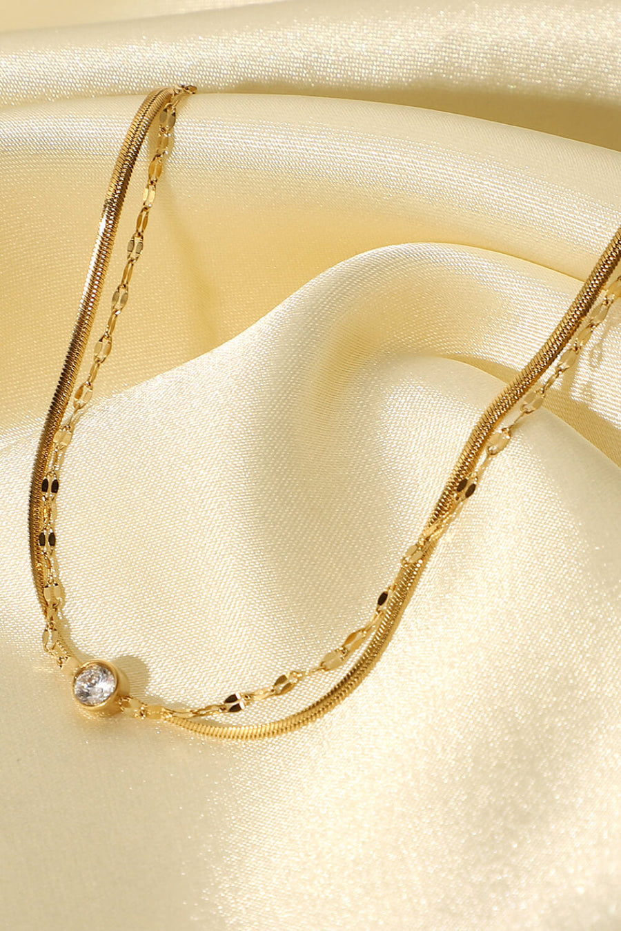 Gold double-strand bracelet with pavé charm and delicate chains.