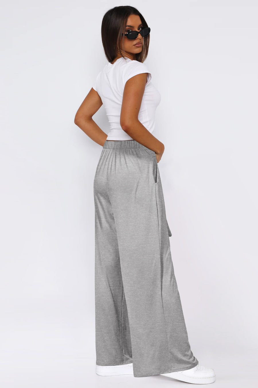 Soft drape palazzo trousers in light gray with a tie detail and elastic waist.