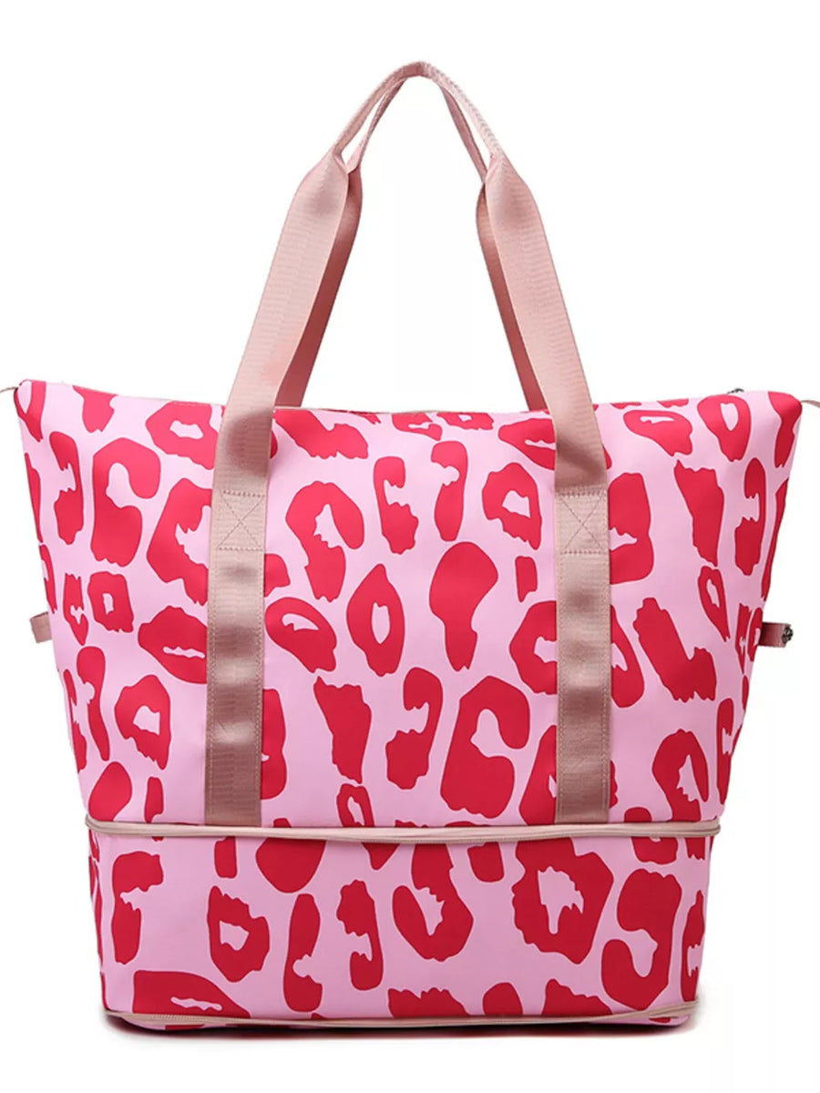 Vibrant leopard print travel bag with pink and red animal print and tan straps.