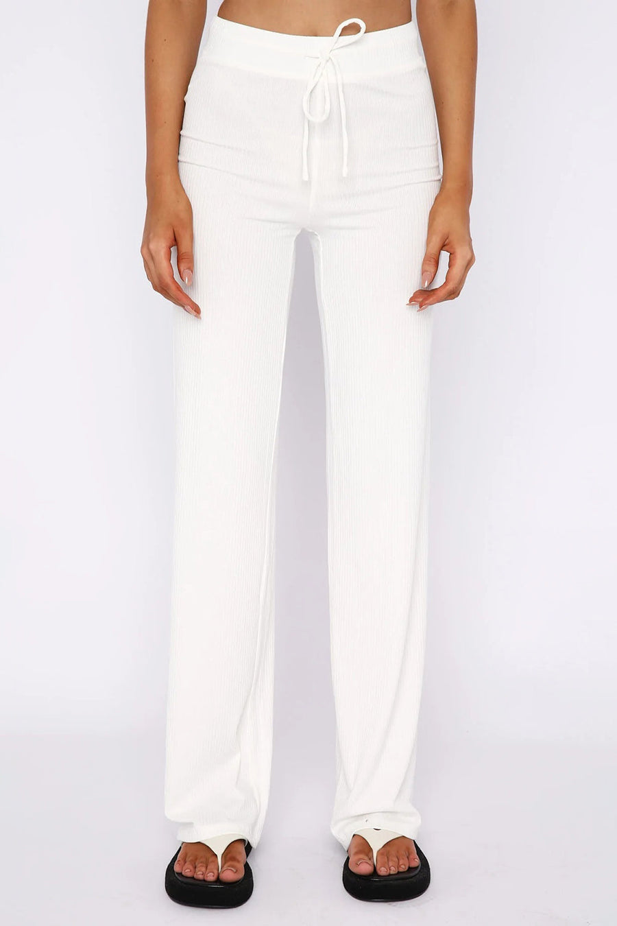White ribbed wide leg pants with drawstring waist, styled with platform flip-flops.